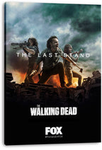 The Walking Dead canvas wall art print viewed from an angle, featuring three survivors with weapons amid flames, wreckage, and raised hands.