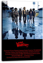 The Warriors wall art canvas presents seven figures striding down a wet blue-gray street, with puddle reflections and bold red title text.