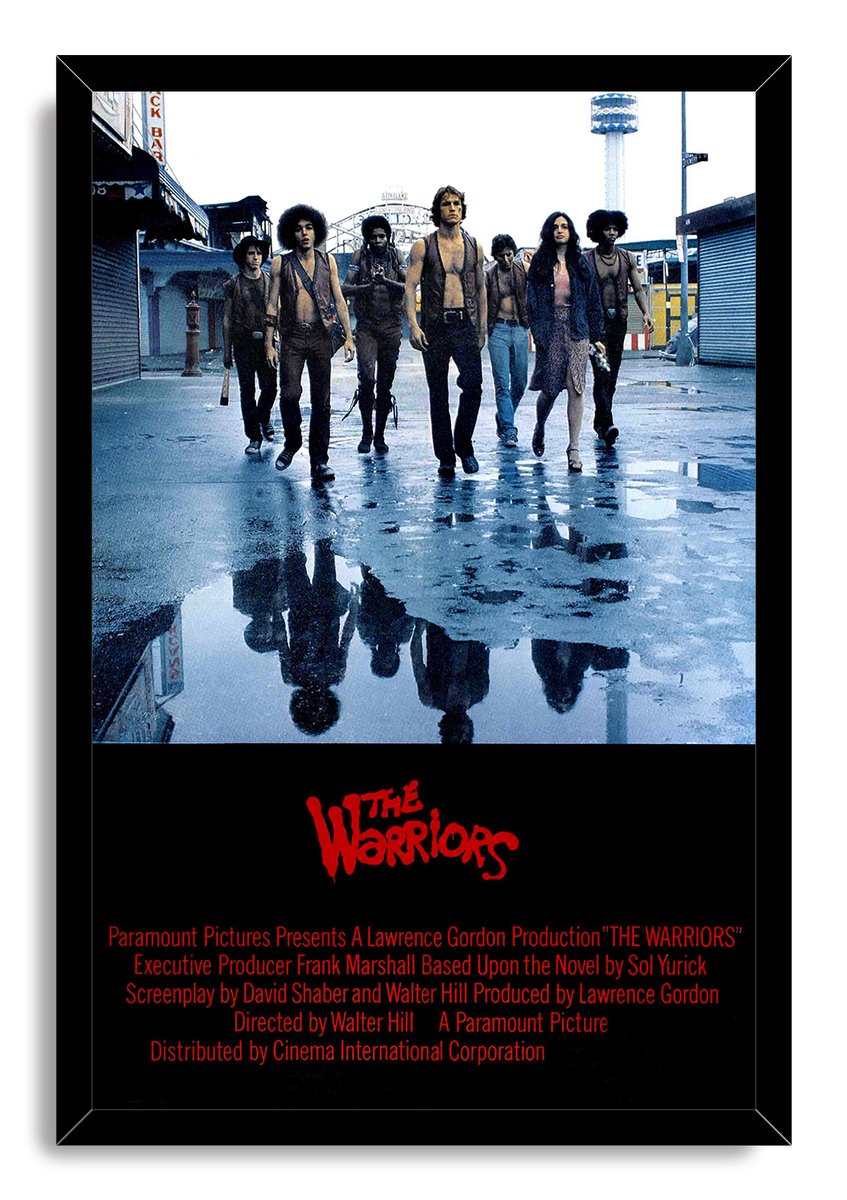 The Warriors framed wall art print features seven people on a rain-slick city street, mirrored in puddles above red film credits.