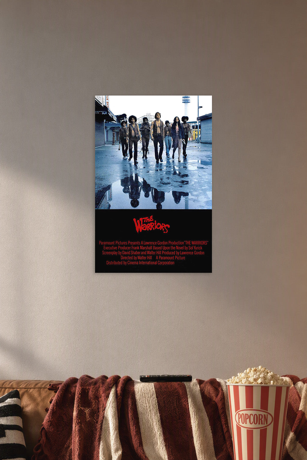 The Warriors Movie in a cozy movie room above a brown sofa with popcorn.