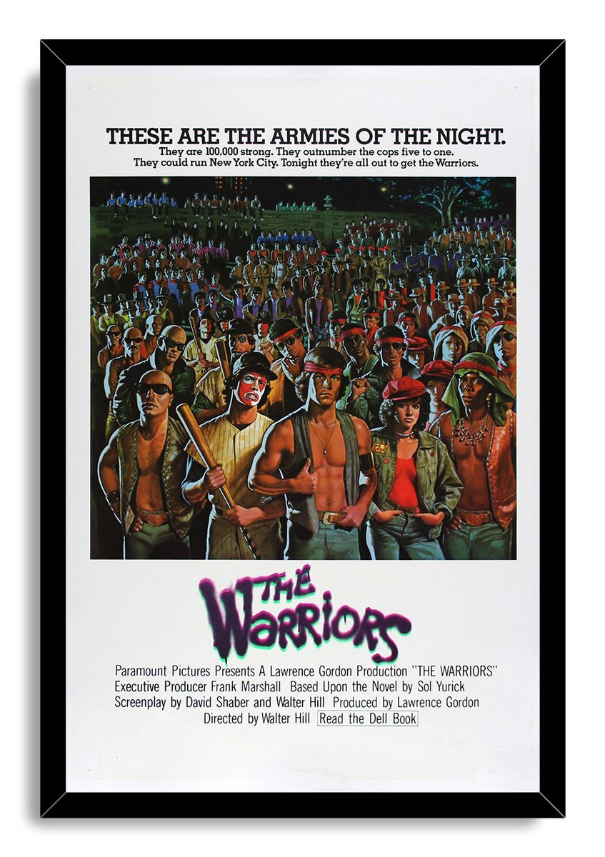 The Warriors framed wall art print in a black frame, depicting a large nighttime gang crowd and vivid foreground characters.