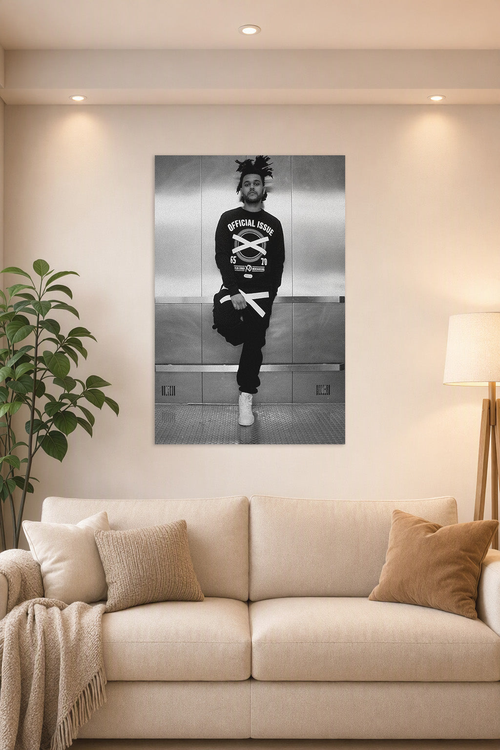 The Weeknd in a bright living room above a beige sofa.