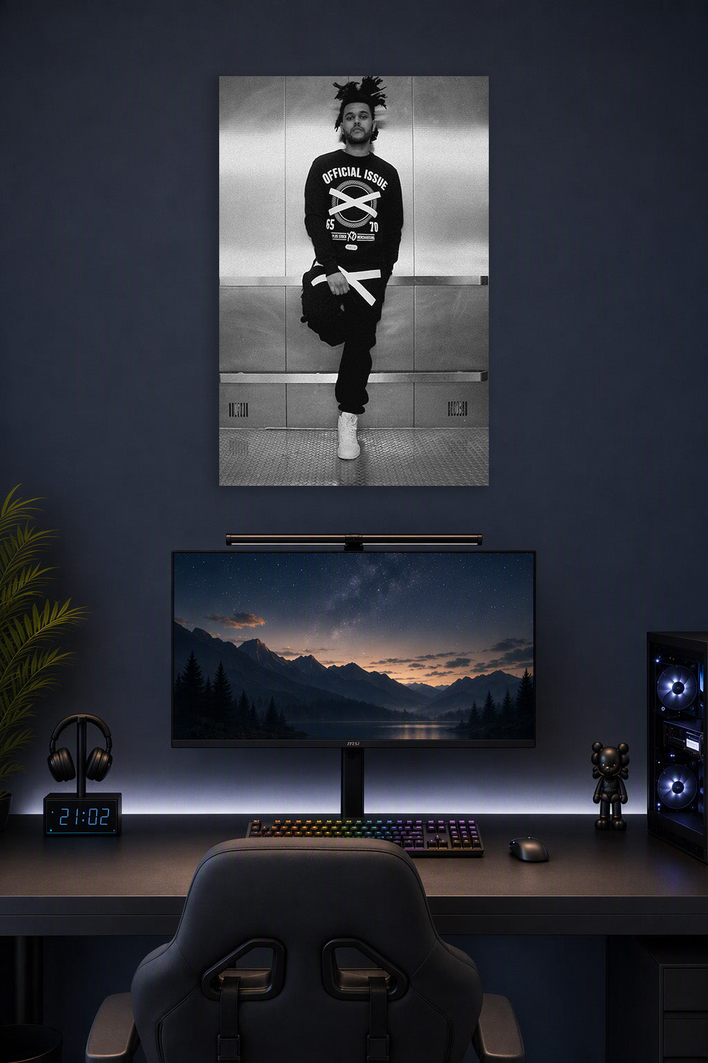 The Weeknd in a gaming desk setup above a monitor.