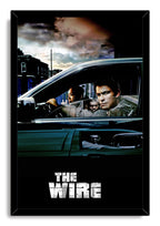 The Wire framed wall art print presents men in a dark sedan under a moody sky, bordered by a black frame with white title text.