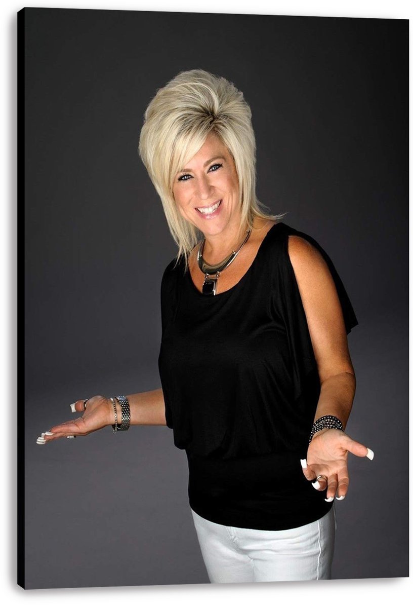 Theresa Caputo canvas wall art print featuring her smiling in a black top and white pants with hands extended.