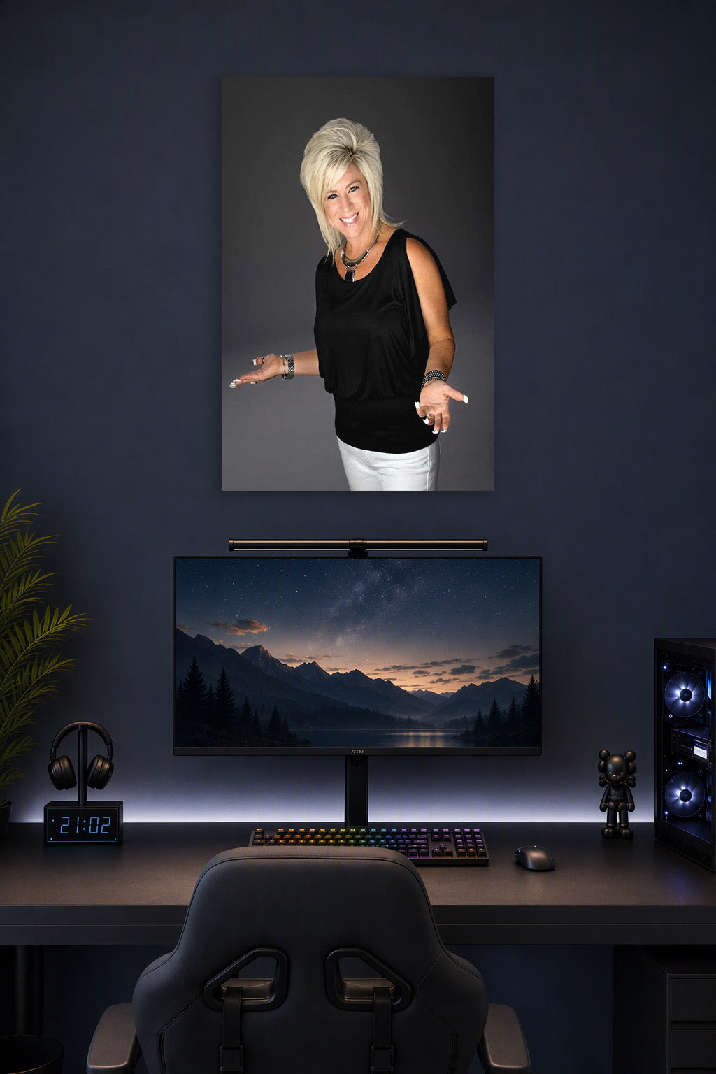 Theresa Caputo in a gaming desk setup above a monitor.