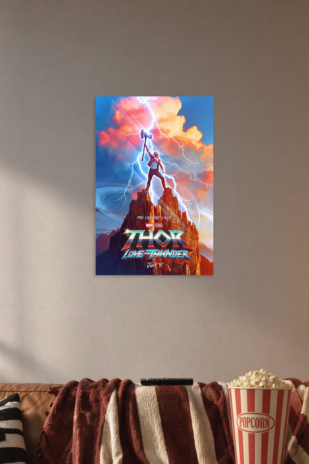 Thor Love and Thunder in a cozy movie room above a brown sofa with popcorn.