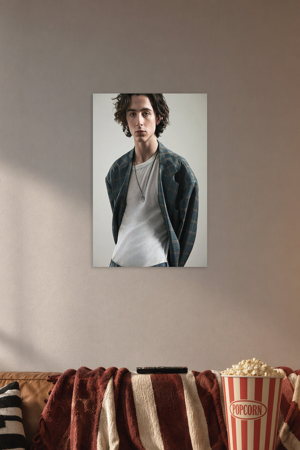 Timothée Chalamet in a cozy movie room above a brown sofa with popcorn.