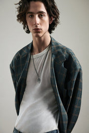 Timothée Chalamet wall art print portrays the actor in a plaid blazer, white shirt, and pendant necklace against gray.