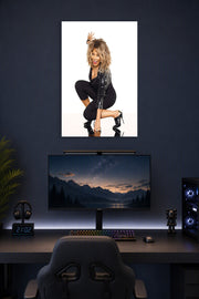 Tina Turner in a gaming desk setup above a monitor.