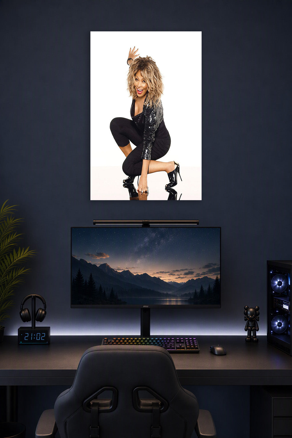 Tina Turner in a gaming desk setup above a monitor.