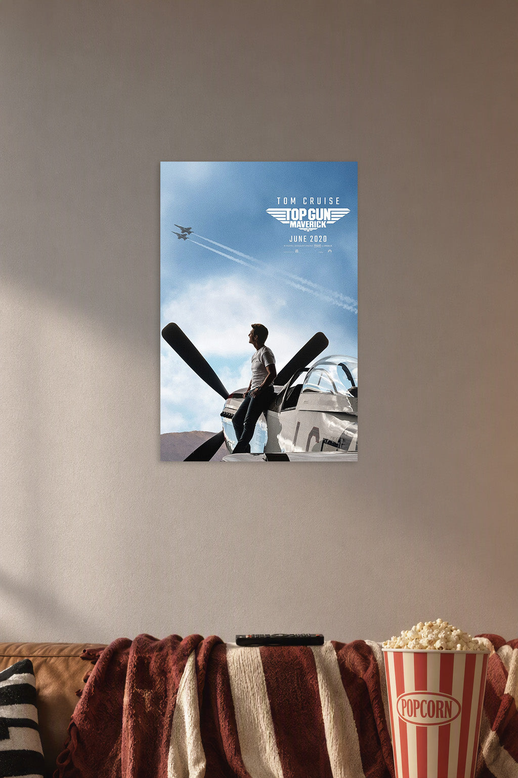 Tom Cruise Top Gun Maverick in a cozy movie room above a brown sofa with popcorn.