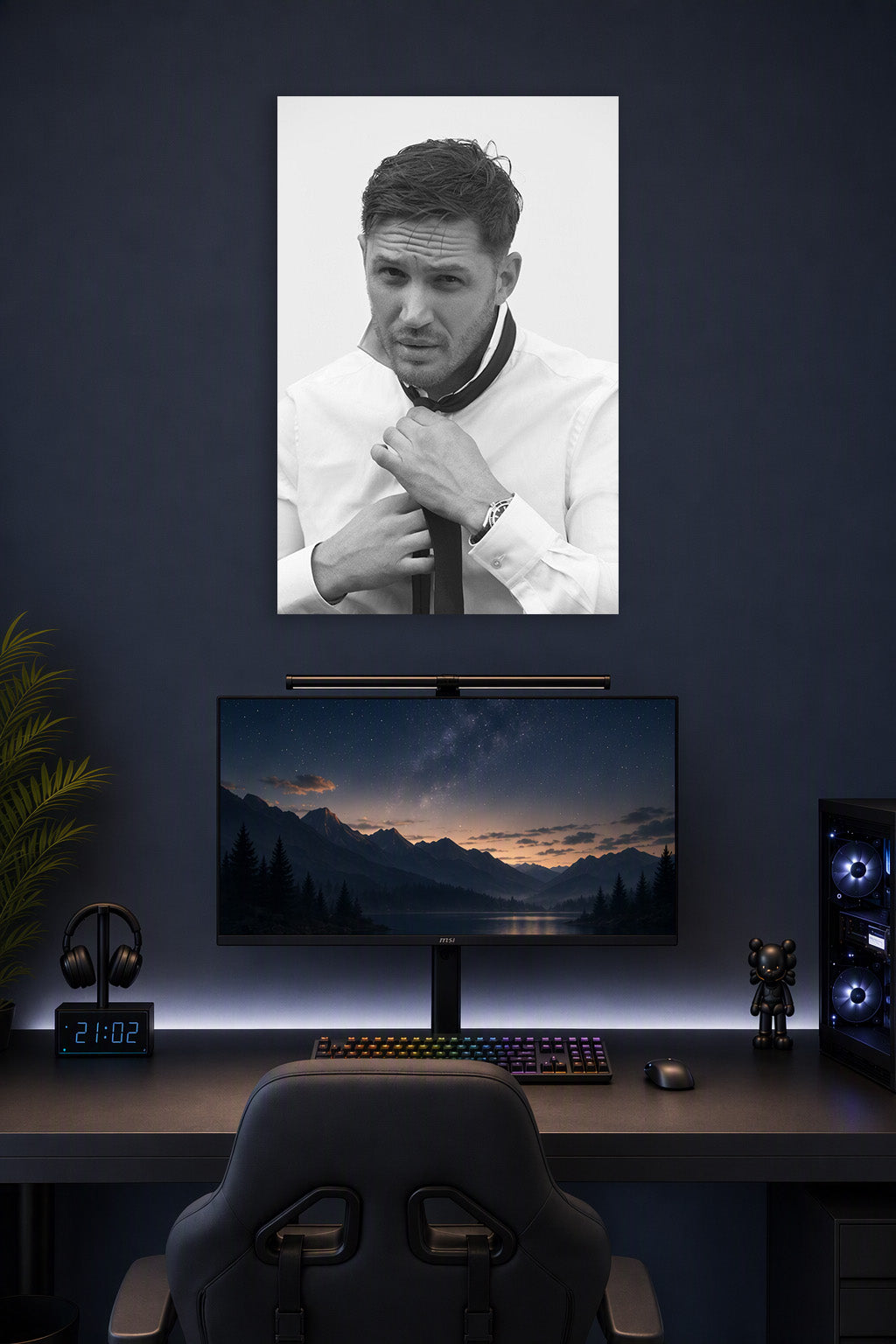 Tom Hardy in a gaming desk setup above a monitor.