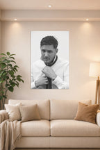 Tom Hardy in a bright living room above a beige sofa.