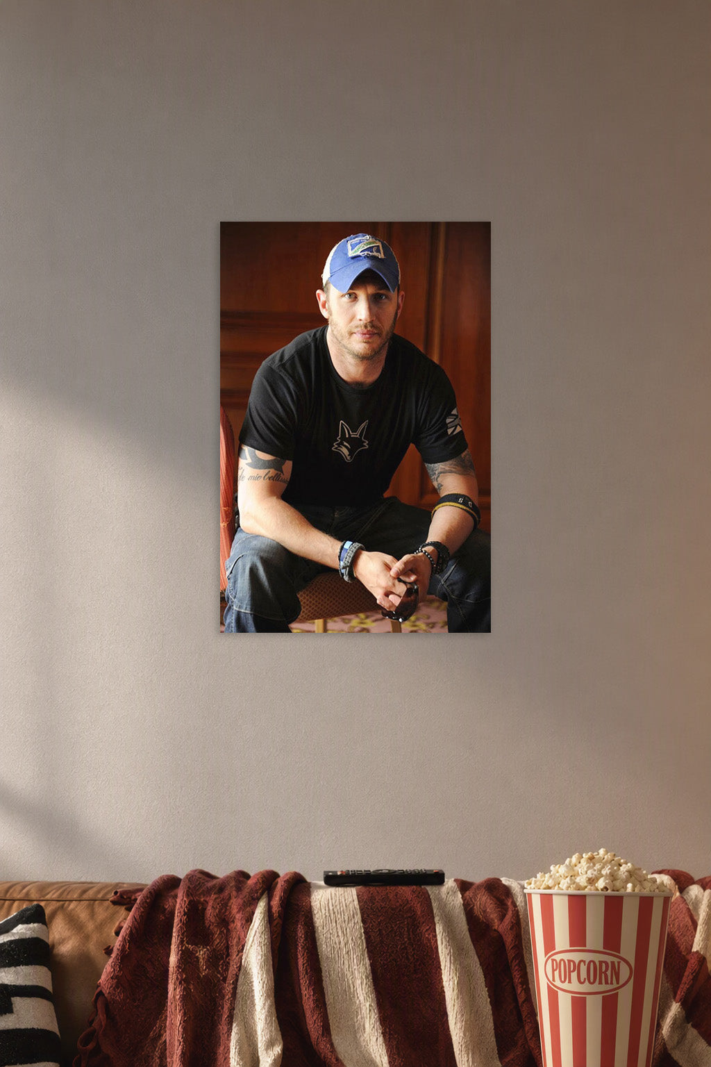 Tom Hardy in a cozy movie room above a brown sofa with popcorn.