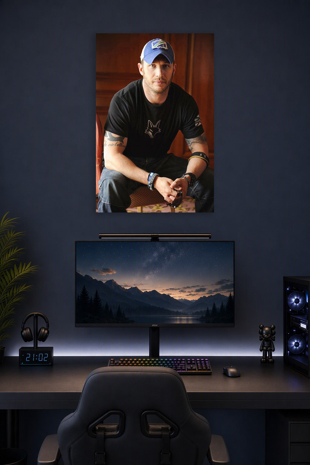 Tom Hardy in a gaming desk setup above a monitor.