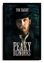 Tom Hardy Peaky Blinders framed wall art print portraying a bearded man in a black hat before a shadowy blue brick wall.