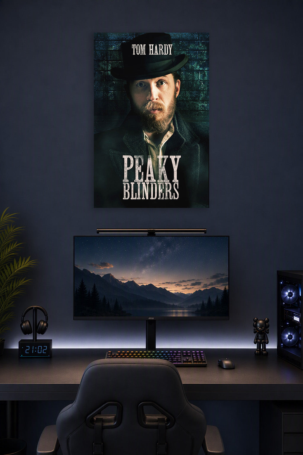 Tom Hardy Peaky Blinders in a gaming desk setup above a monitor.