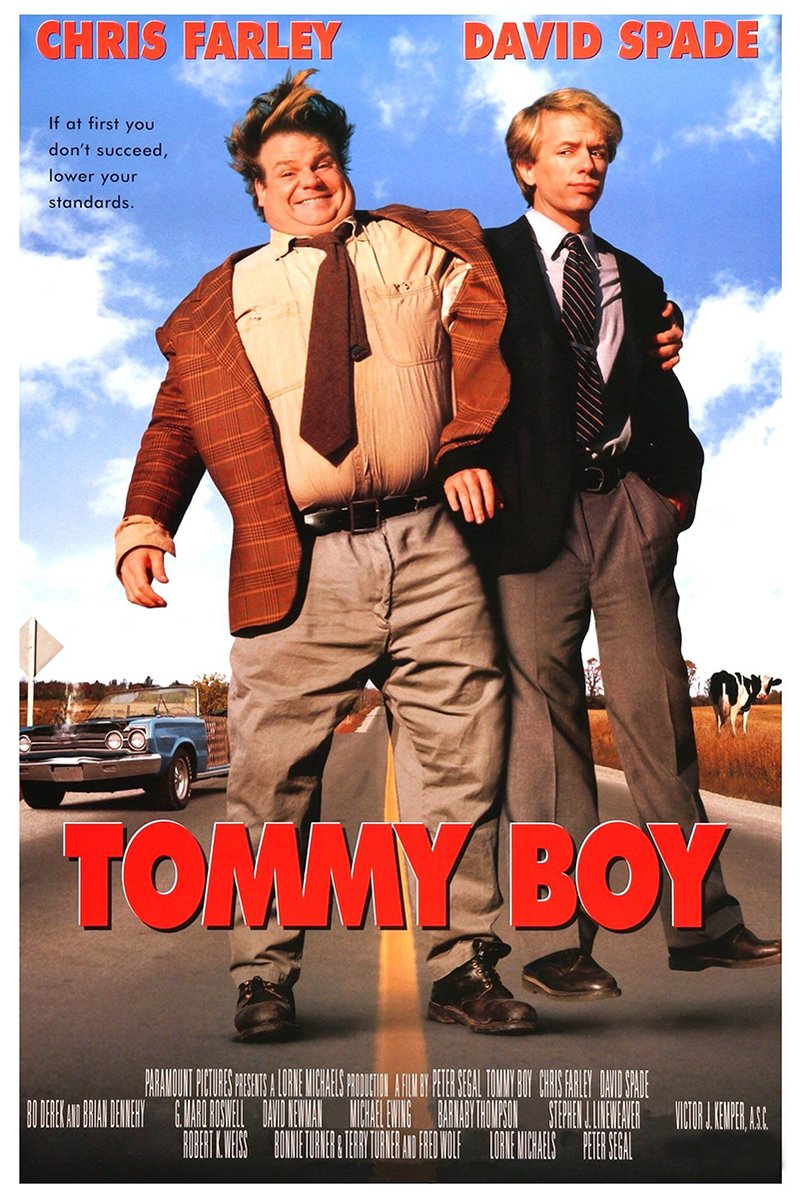 Tommy Boy movie poster with Chris Farley and David Spade on a country road, a blue car, cows, and bold red title text.