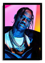 Travis Scott framed wall art print with a black border, depicting the rapper in braids and layered chains under vibrant blue, pink and orange light.