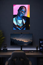 Travis Scott in a gaming desk setup above a monitor.