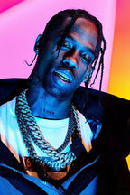 Travis Scott poster portrait with braided hair, metallic grillz and layered chains against a vivid pink, orange and blue background.