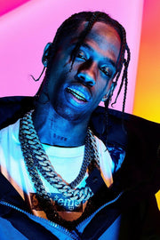 Travis Scott poster portrait with braided hair, metallic grillz and layered chains against a vivid pink, orange and blue background.