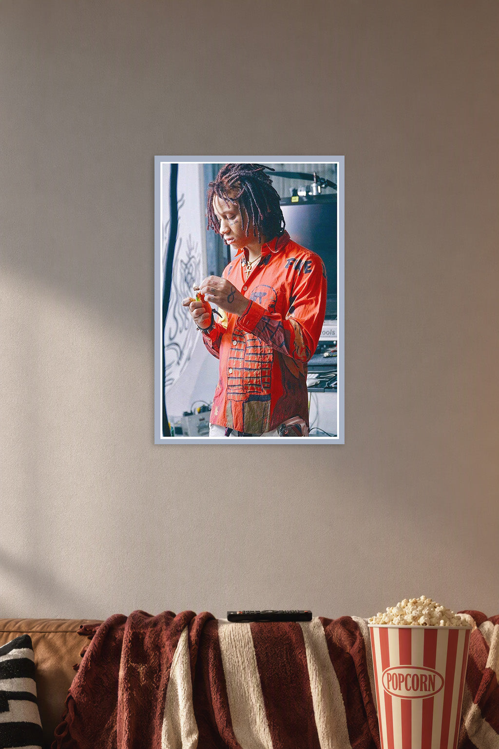Trippie Redd in a cozy movie room above a brown sofa with popcorn.