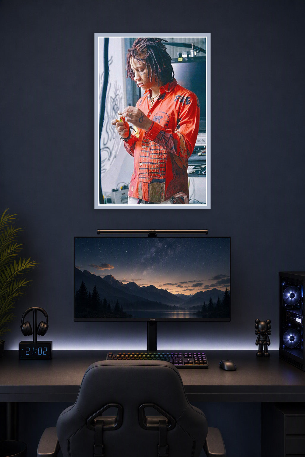 Trippie Redd in a gaming desk setup above a monitor.