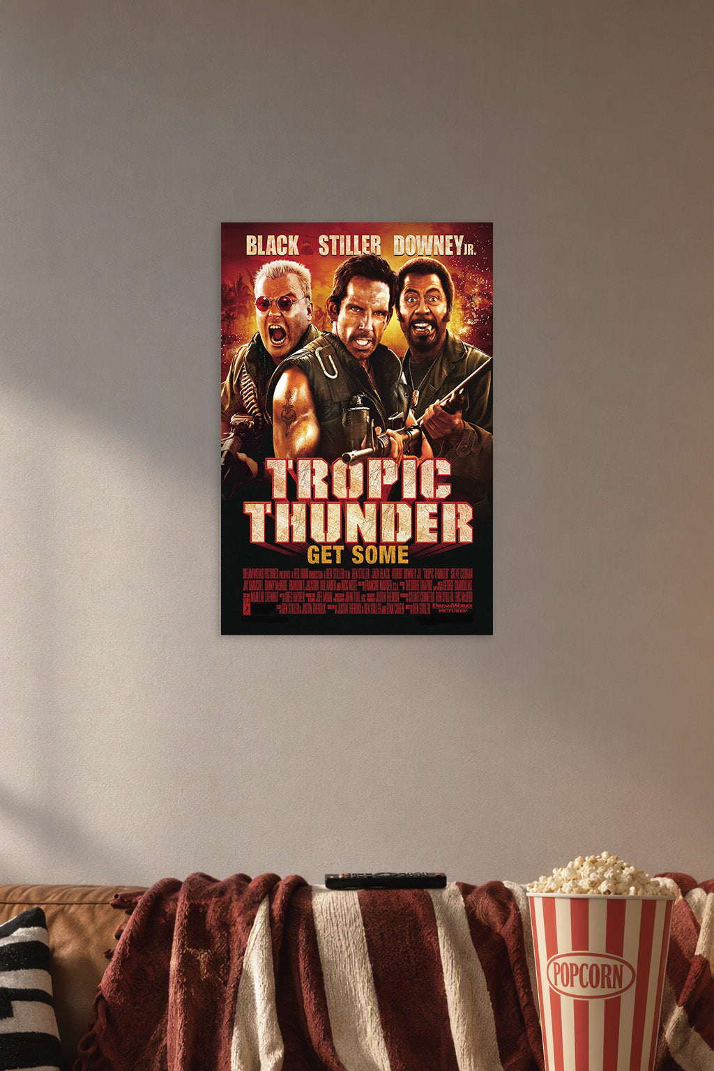 Tropic Thunder Movie Poster in a cozy movie room above a brown sofa with popcorn.