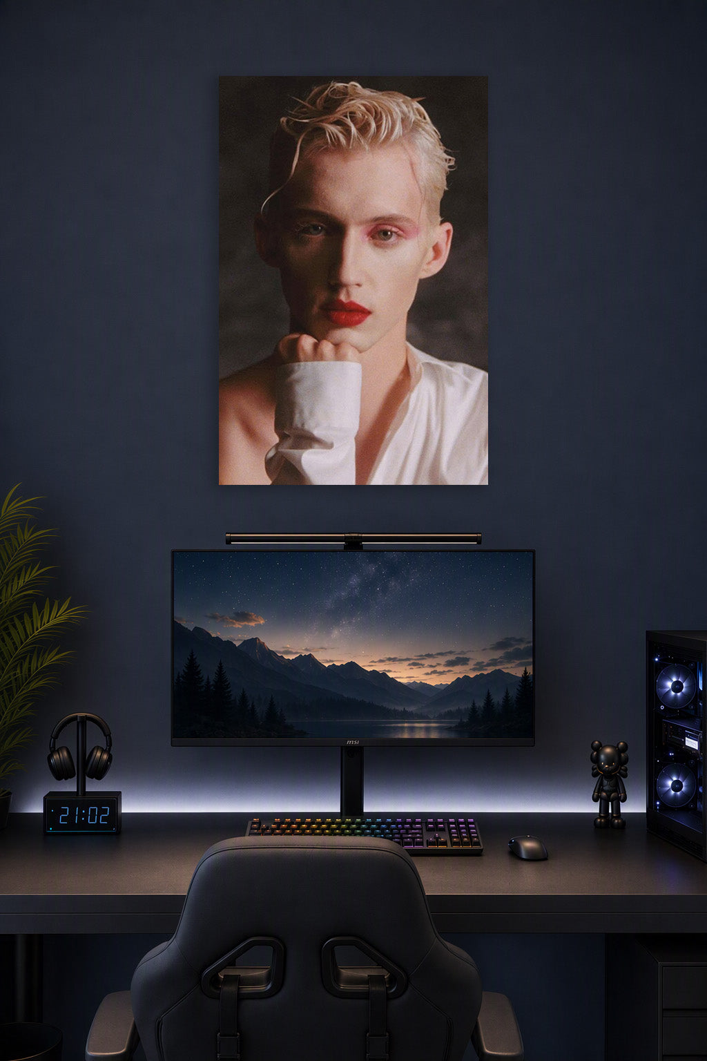 Troye Sivan in a gaming desk setup above a monitor.