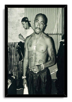Tupac Shakur framed wall art print presents a black-and-white portrait of the shirtless rapper in a sleek black frame.