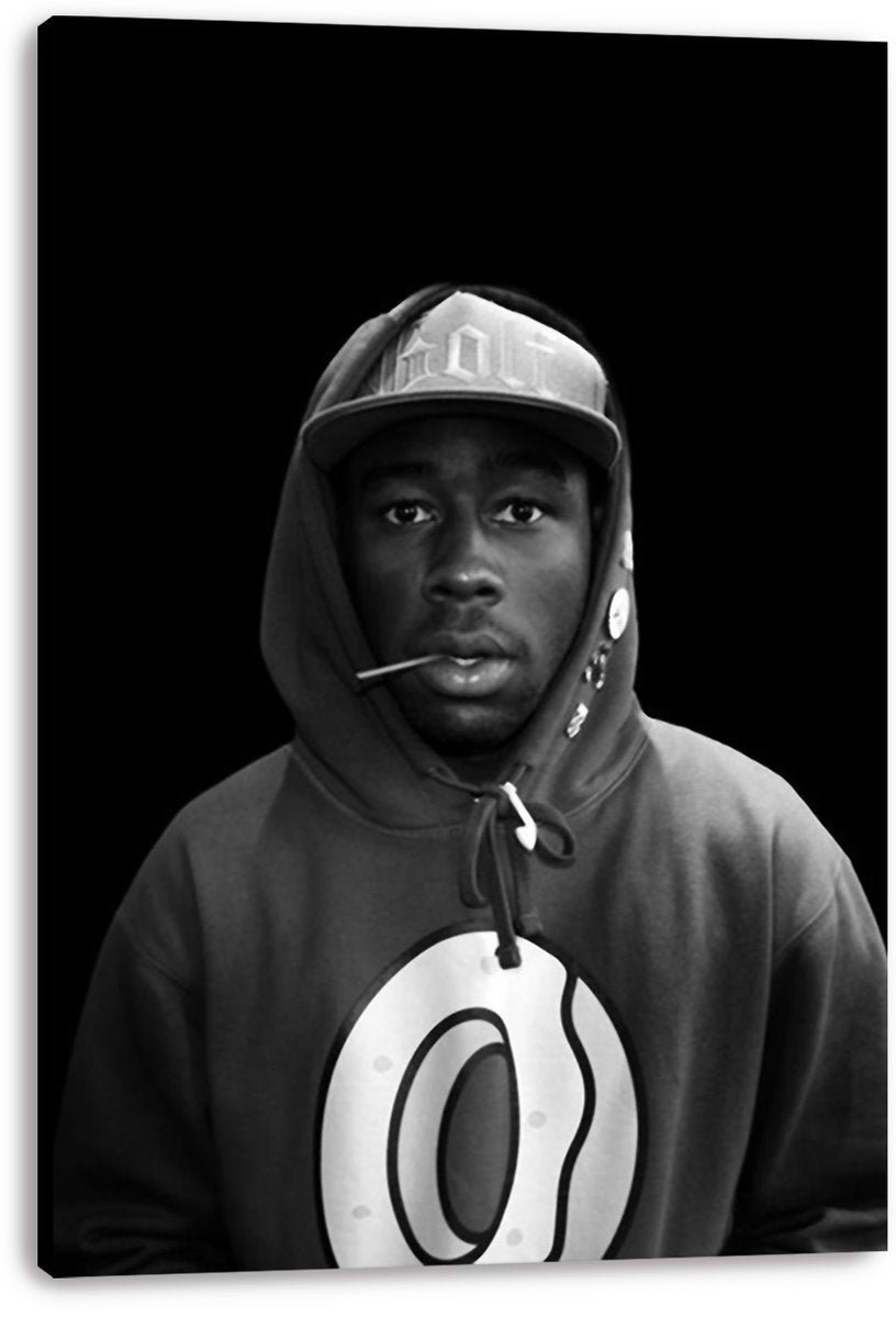 Tyler, The Creator canvas wall art print displays a monochrome portrait in a cap and hoodie, with a black background.
