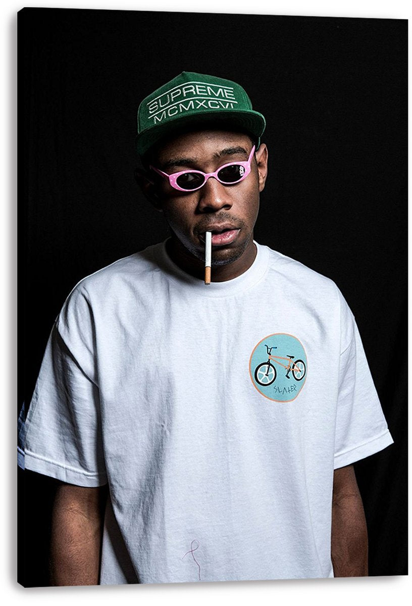 Tyler, The Creator canvas wall art print displays a dark portrait with pink sunglasses, green cap, white T-shirt, and cigarette.