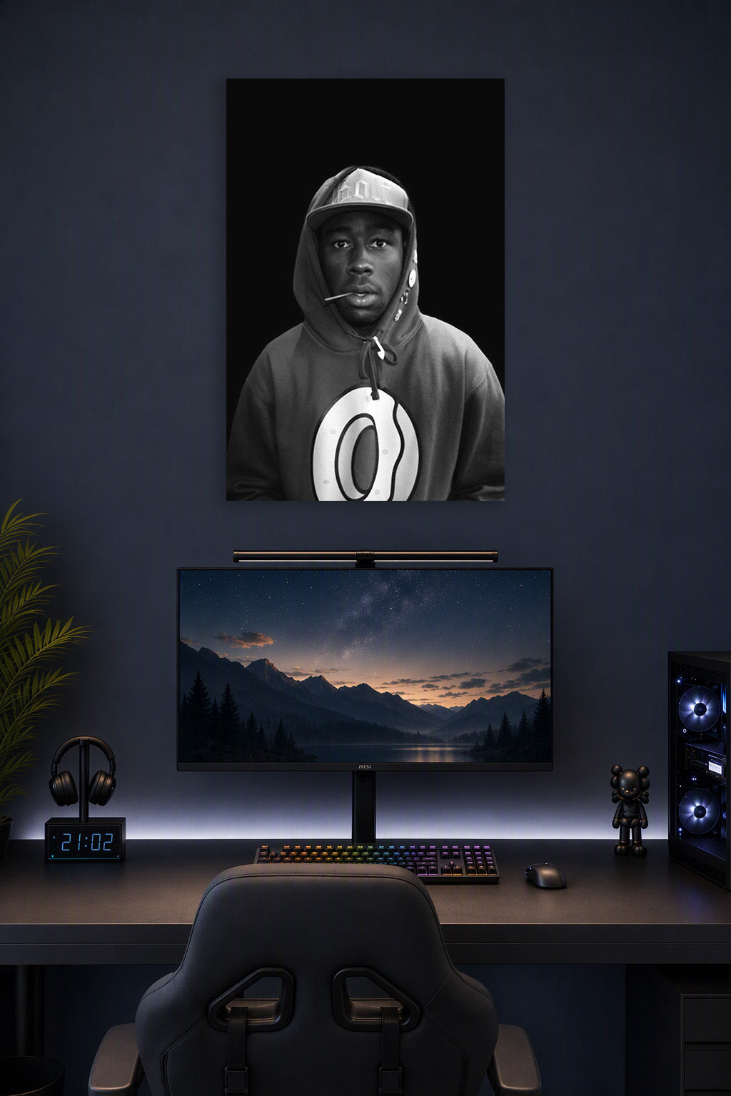Tyler, The Creator in a gaming desk setup above a monitor.