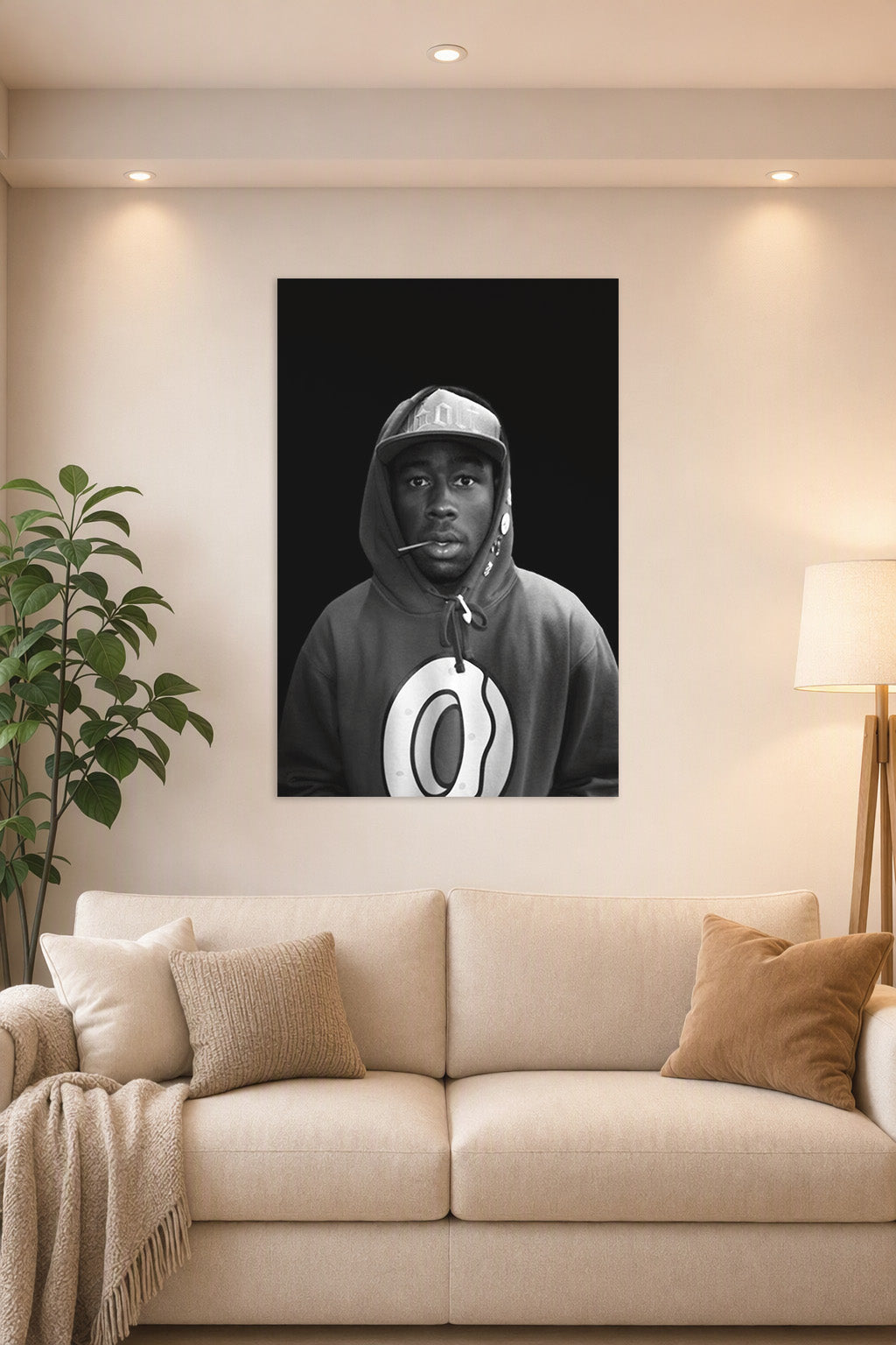Tyler, The Creator in a bright living room above a beige sofa.