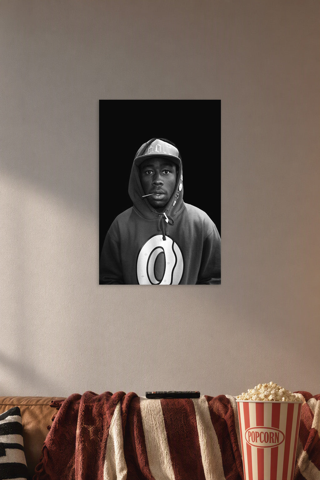 Tyler, The Creator in a cozy movie room above a brown sofa with popcorn.