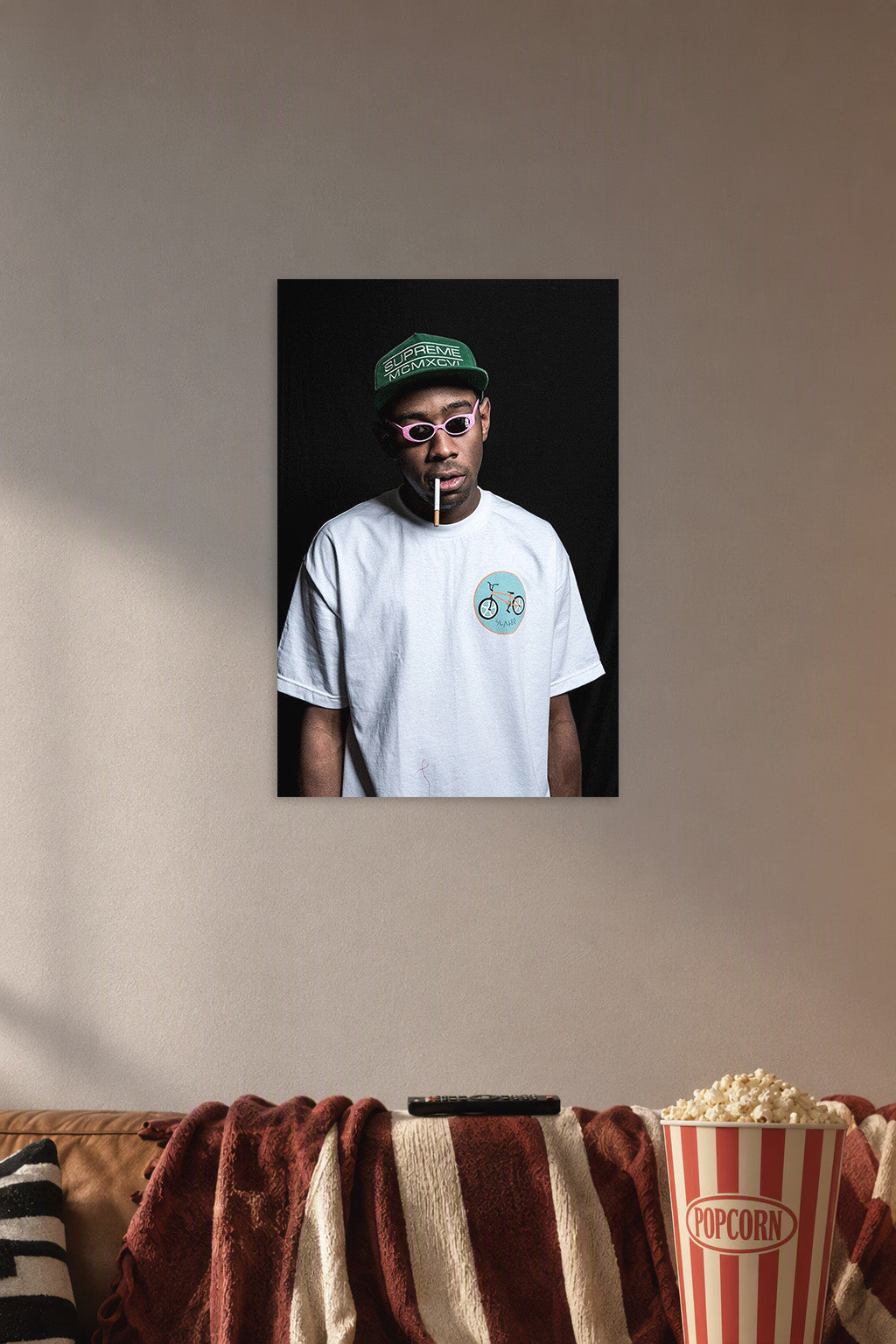 Tyler, The Creator in a cozy movie room above a brown sofa with popcorn.