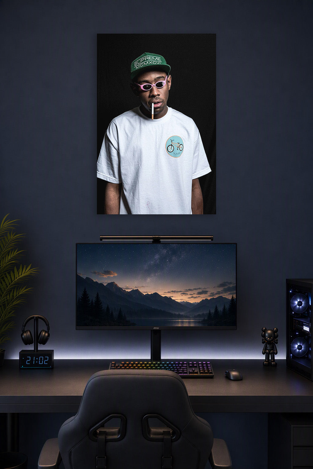Tyler, The Creator in a gaming desk setup above a monitor.