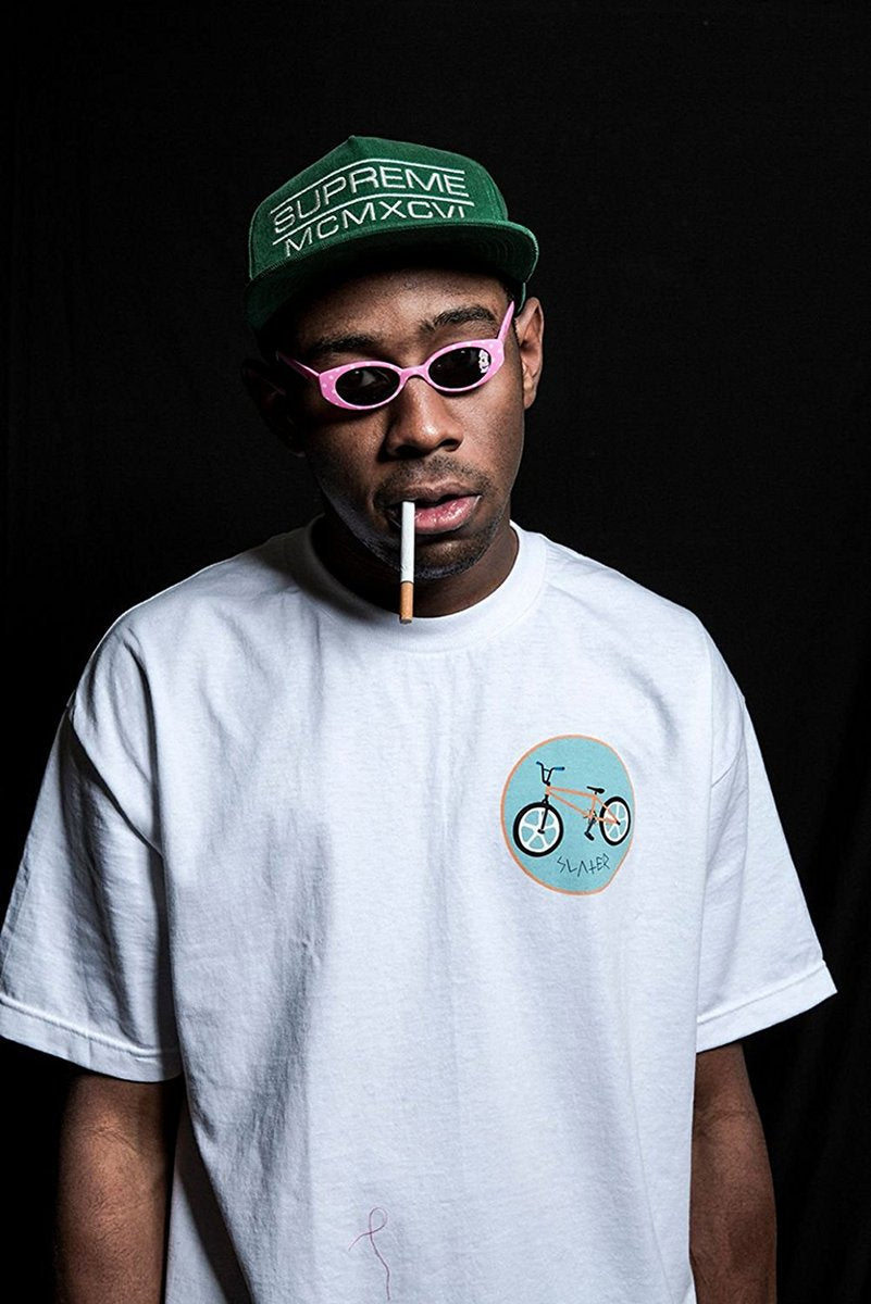 Tyler, The Creator wall art print features a portrait in pink sunglasses, a green cap, and white T-shirt against black.
