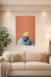 Tyler, The Creator in a bright living room above a beige sofa.