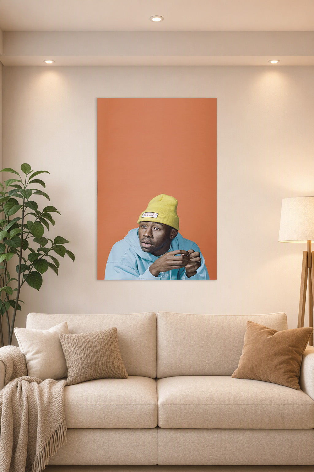 Tyler, The Creator in a bright living room above a beige sofa.