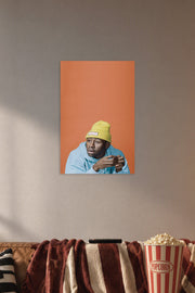 Tyler, The Creator in a cozy movie room above a brown sofa with popcorn.