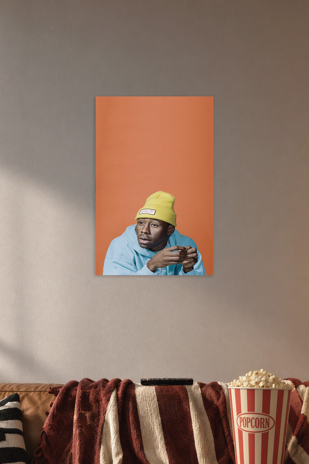 Tyler, The Creator in a cozy movie room above a brown sofa with popcorn.
