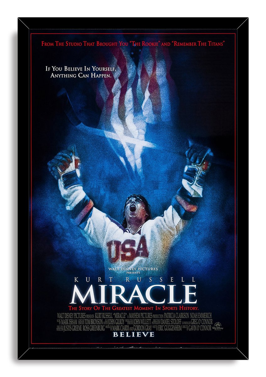 Miracle movie poster wall art print in a black frame portrays a triumphant USA hockey player beneath a stylized American flag.
