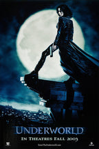 Underworld poster depicts Selene in a black coat holding a handgun on a rooftop before a full moon and blue city skyline.