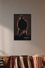 Unforgiven Movie Poster in a cozy movie room above a brown sofa with popcorn.