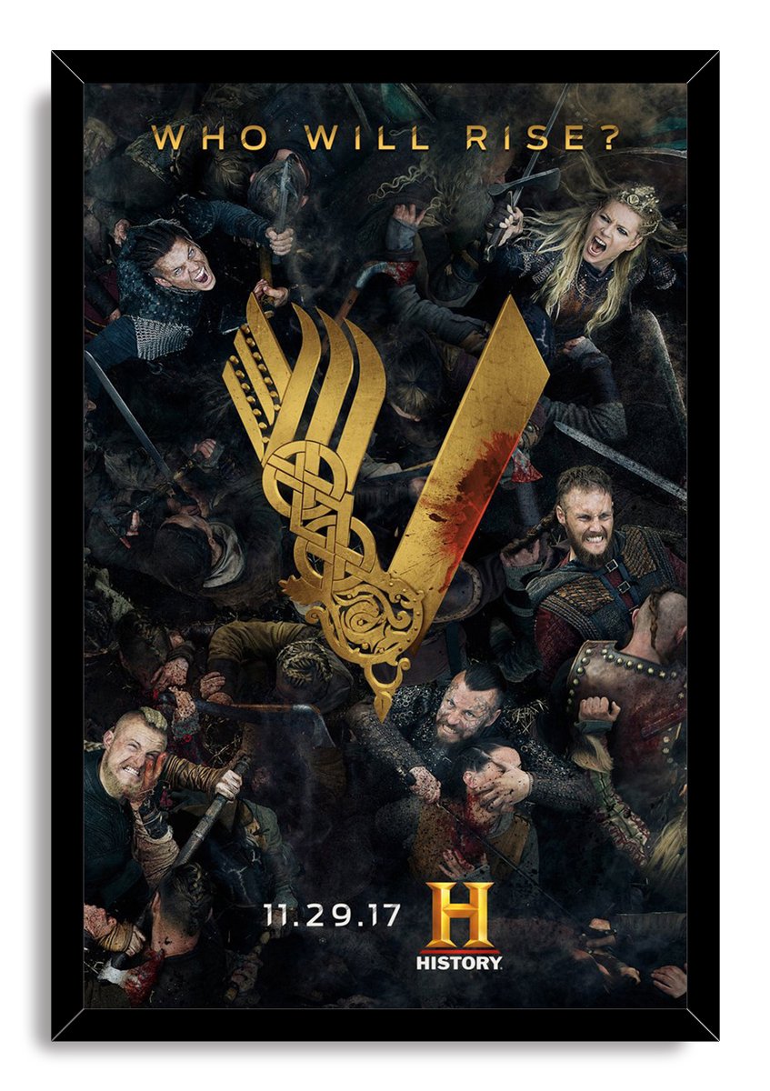 Vikings framed wall art print depicts a crowded warrior battle around a gold V symbol, set in a sleek black frame.
