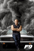 Vin Diesel F9 The Fast Saga poster with Dominic Toretto standing arms crossed before a silver muscle car and storm clouds.