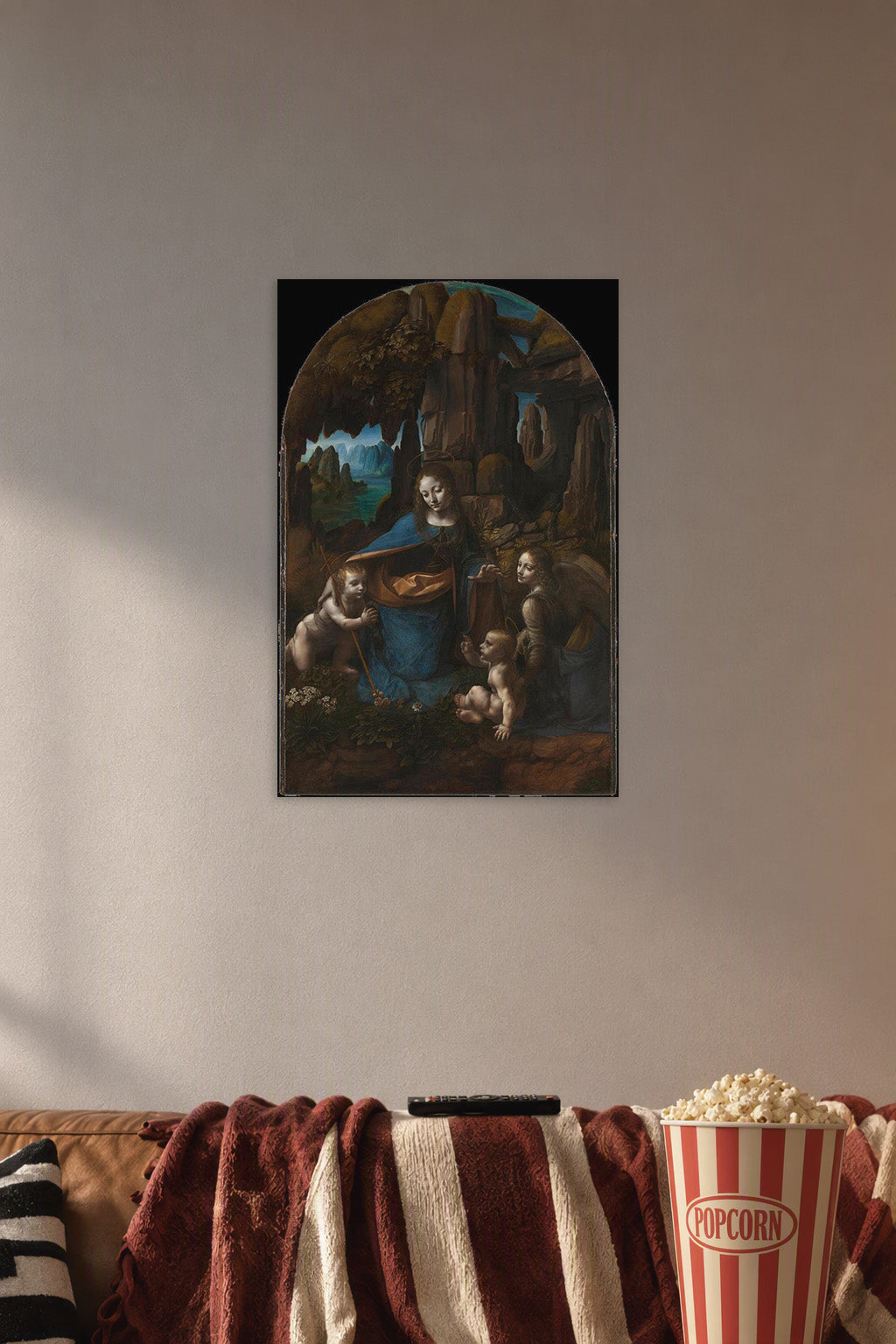 Virgin of the Rocks by Leonardo da Vinci in a cozy movie room above a brown sofa with popcorn.